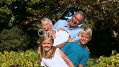 Cheerful multi-generation family posing in a park