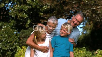 Cheerful multi-generation family embracing in a park