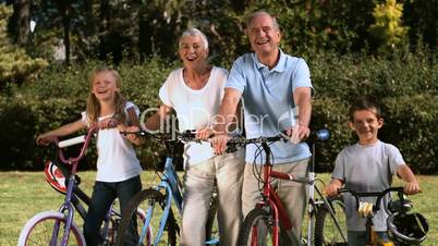 Multi-generation family standing in a park with their bicycles