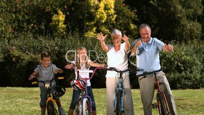 Multi-generation family posing in a park with their bicycles