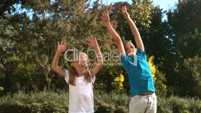 Happy siblings jumping together in their garden