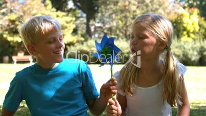 Siblings blowing a pinwheel together