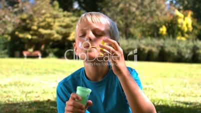 Young boy blowing into a bubble wand