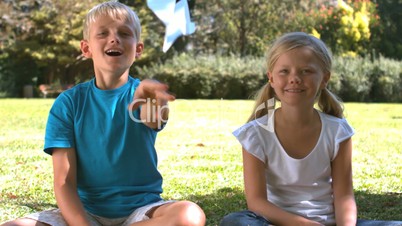 Brother throwing a paper airplane next to his sister