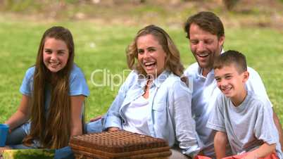 Cheerful family having a picnic in a park