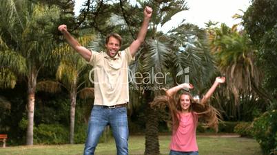 Happy father jumping on a trampoline with his daughter