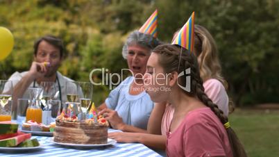 Little girl blowing the candles on her birthday cake