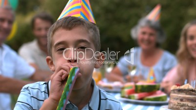 Little boy blowing party horn
