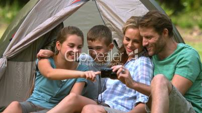 Cheerful family looking at photo on camera
