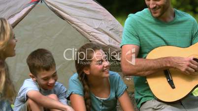 Father playing guitar for his family