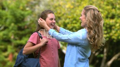 Mother arranging her daughter's hairs