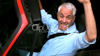 Man raising up his hands in a car