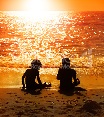 kinder sitzen am strand