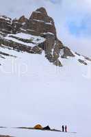 tents and hikers in snow mountains