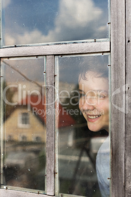 The boy cheerfully looks out of the window