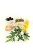 Olivenölflasche mit Oliven und Zweig