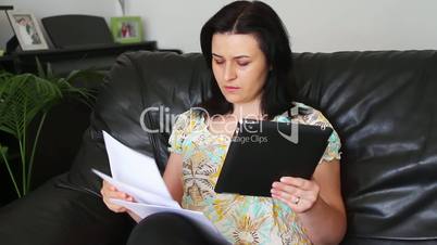 Young women with tablet pc and bills
