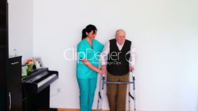 Carer Helping Elderly Senior Man Using Walking Frame