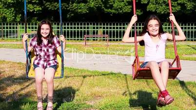 Happy little girls swinging