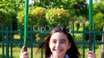 Little girl smiling on a swing