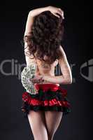 Sexy flamenco dancer posing with fan of money