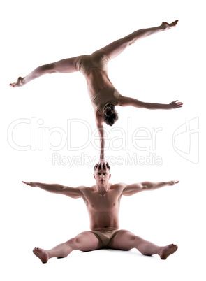 Athletic people showing acrobatic trick in studio