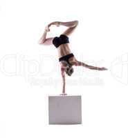 Graceful acrobat posing on cube