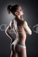 Young topless girl posing in panties
