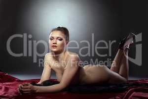 Beautiful nude woman posing lying in studio