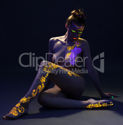 Pretty woman posing with glowing pattern on body