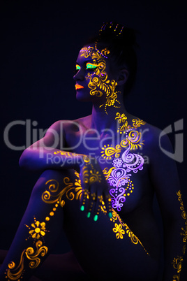 Slender woman posing with colorful UV makeup