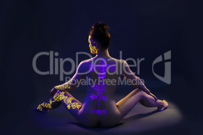 UV glowing pattern on back of nude slim model