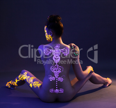 UV glowing pattern on back of naked woman