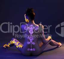 UV glowing pattern on back of naked woman