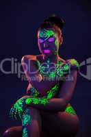 Naked woman posing with colorful UV makeup