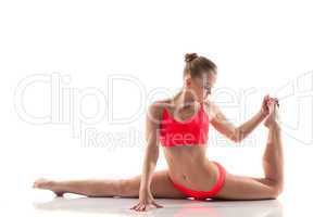 Young gymnast doing stretching exercises in studio