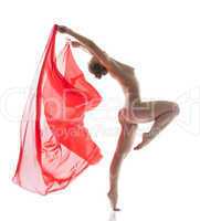 Slender naked woman jumping with cloth in studio