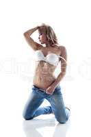 Passionate young model posing in bra and jeans