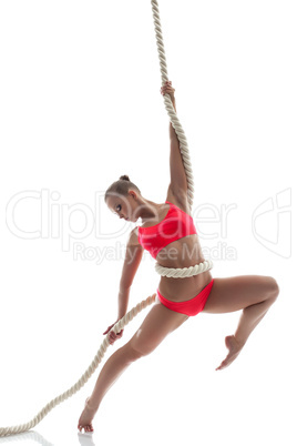 Graceful woman hanging on rope in studio