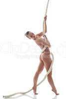 Pretty nude model posing with rope in studio