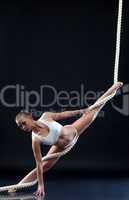 Athletic aerialist posing with rope