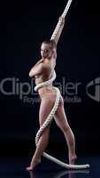 Sexual young woman holds rope in studio