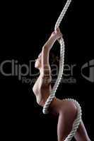 Profile of slim nude woman with rope