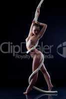 Smiling nude woman posing with rope in studio