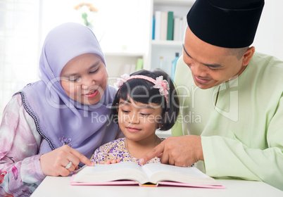 Malay Muslim family reading a book.