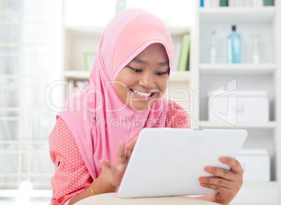 Asian teen using tablet pc computer.