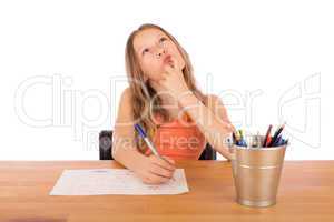 Child sitting at a table trying to make a drawing