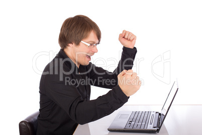 Business man raises arms in front of his laptop