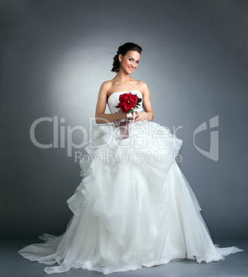Charming bride with bouquet posing in studio