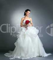 Charming bride with bouquet posing in studio